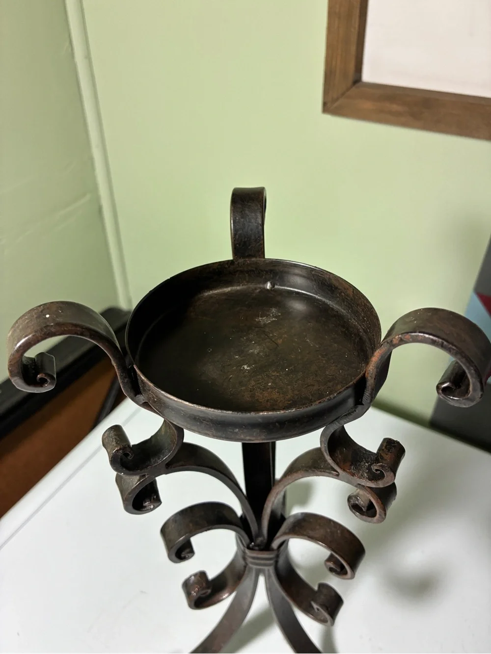vintage wrought iron candle holder features a dark metal scroll and ring design